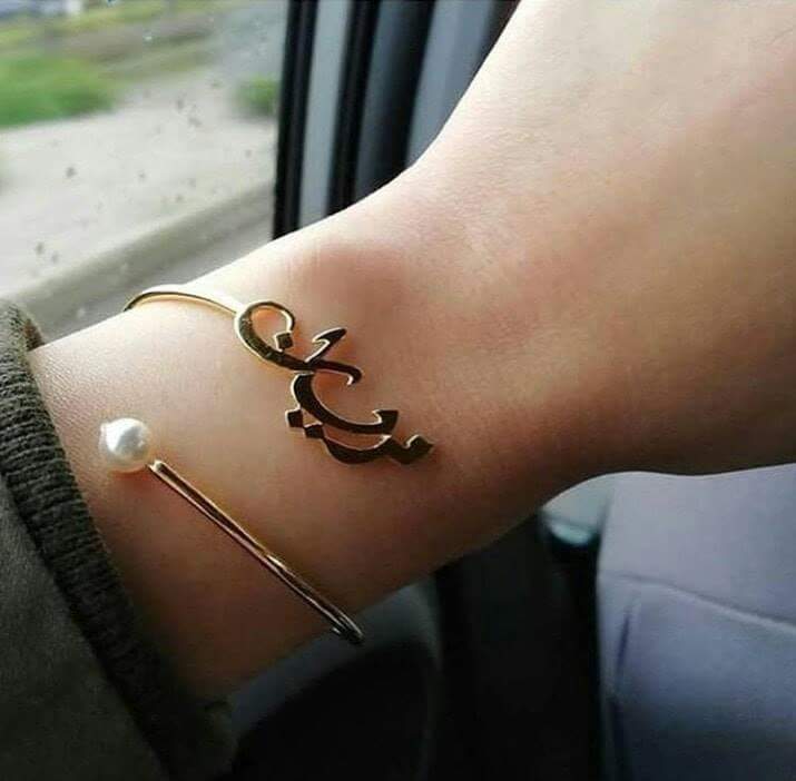 Elegant gold engraved name bangle for women with unique design and pearl accent on wrist