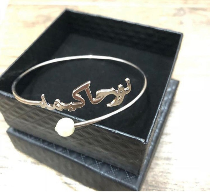 Elegant engraved name bangle for women with a pearl detail displayed in a black gift box