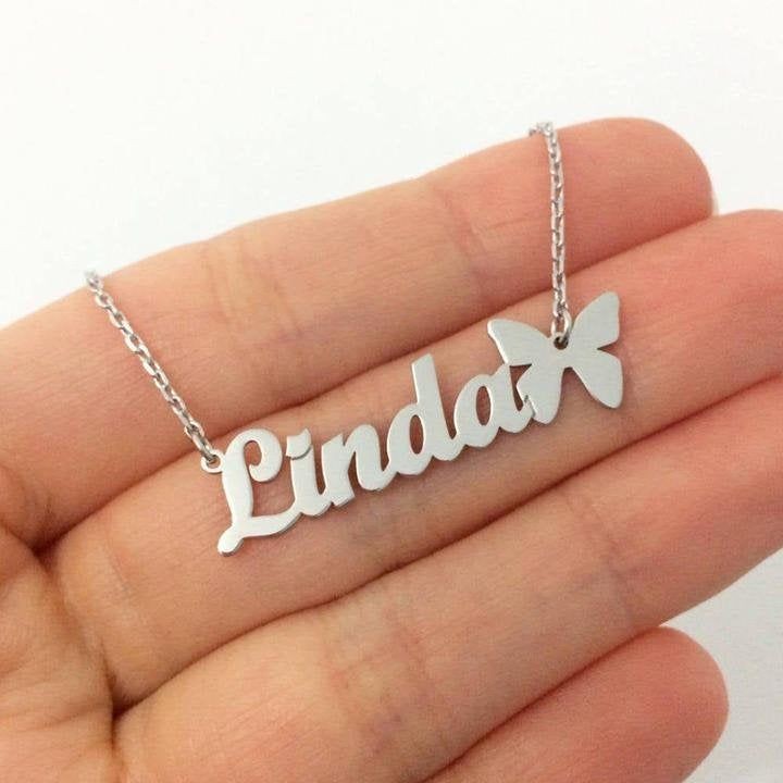 Elegant name plate jewelry silver necklace with Linda name and butterfly pendant held in hand