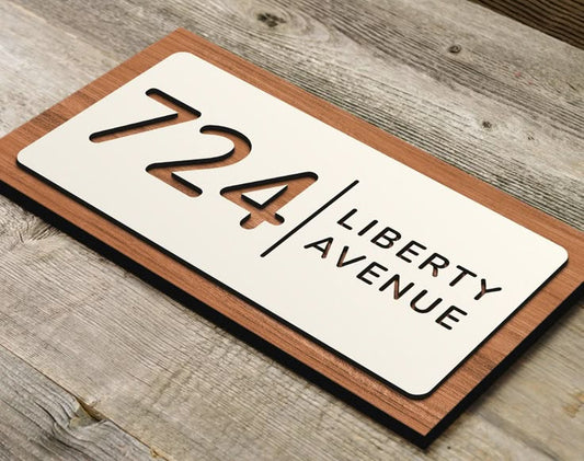 Custom acrylic house name plate with number 724 and Liberty Avenue text on wooden background