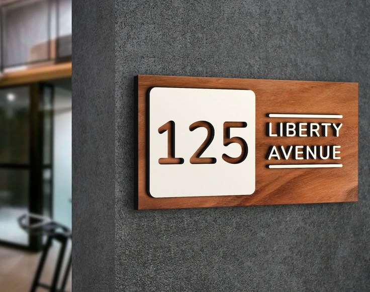 Custom acrylic house name plate with number 125 and Liberty Avenue text on wood background