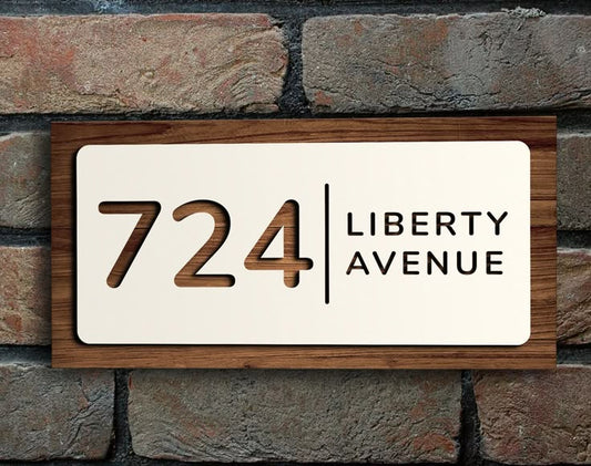 Custom acrylic house name plate with number 724 and Liberty Avenue text mounted on brick wall