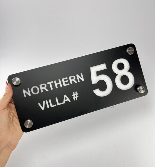 Custom black acrylic house name plate with white text and number 58 mounted with silver screws