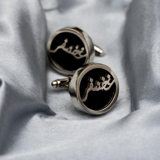 Creativegift.pk custom name cufflinks with black and silver design on gray fabric background