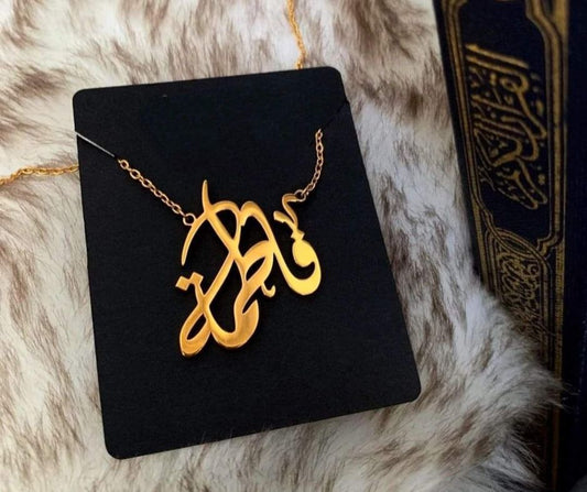 Custom name necklace gold plated with elegant script design displayed on black card