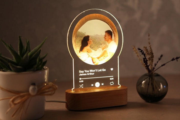 Personalized night light for couples with custom photo and song lyrics on wooden base glowing warmly